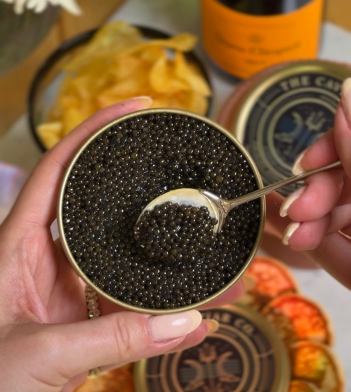 Spooning caviar from an open tin